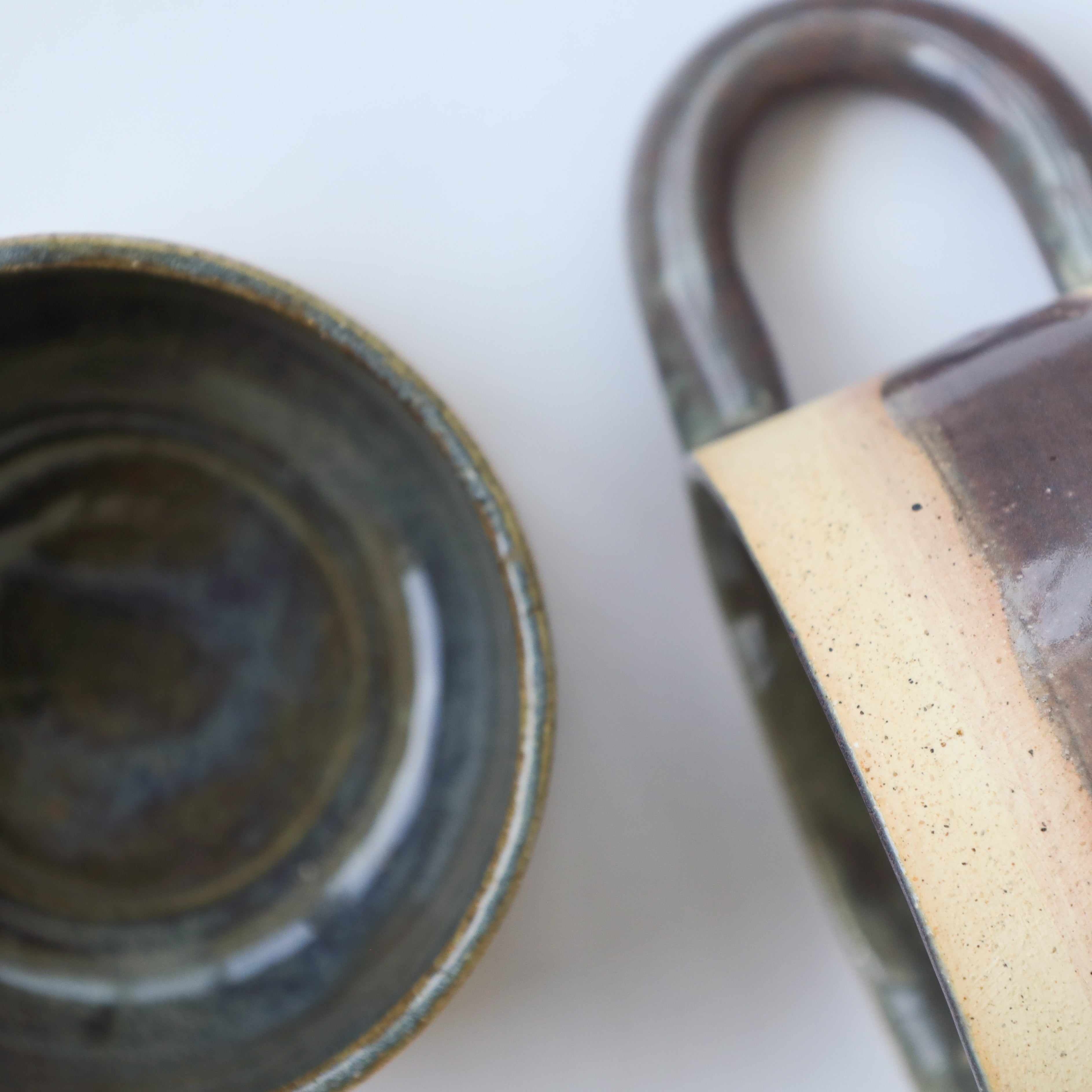 Two ceramic items with a handle on a white background